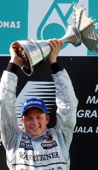 芬兰F1司机Kimi Raikkonen庆祝他的第一个大奖赛胜利，于2003年为马来西亚获得迈凯轮。